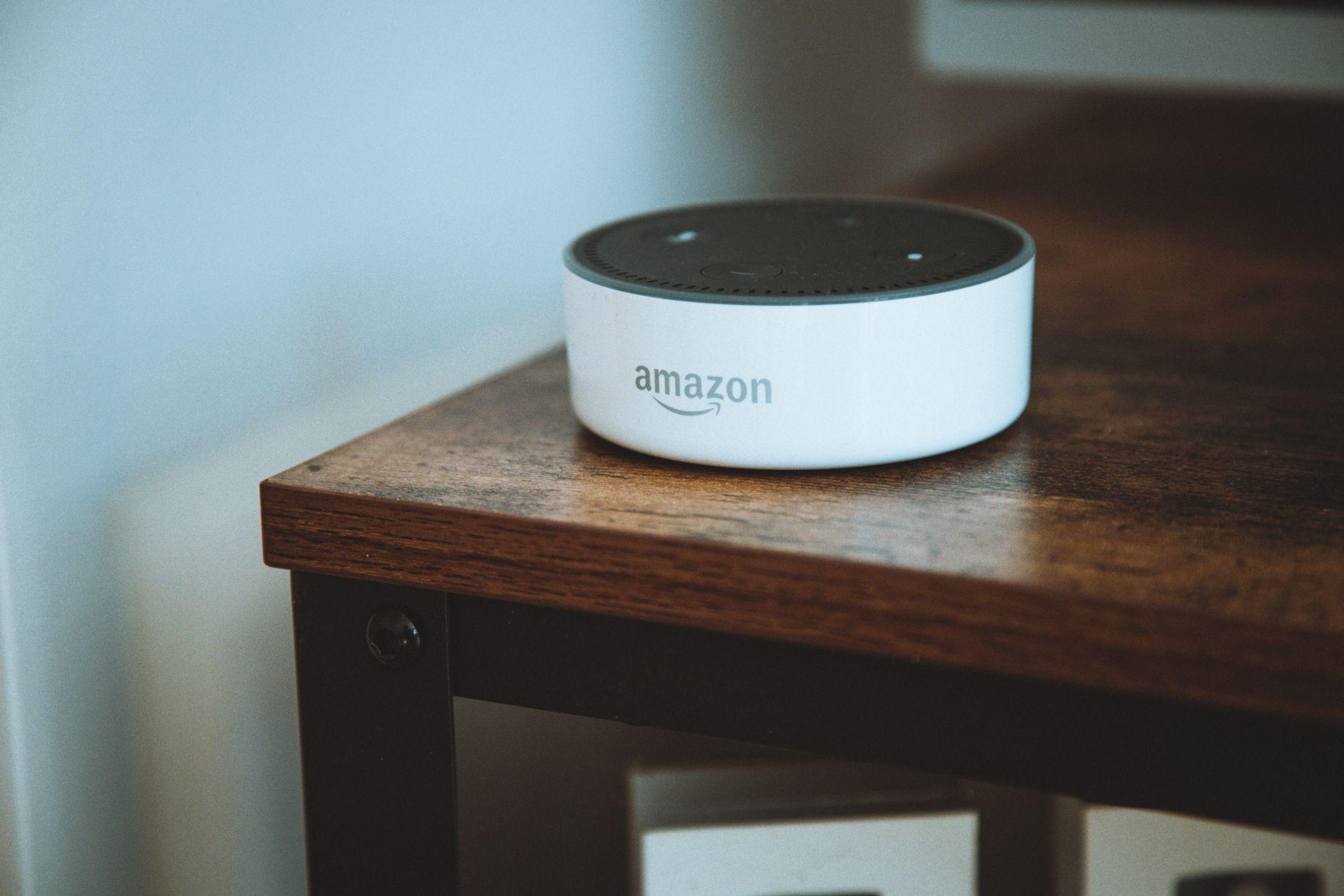 An Amazon Echo on a wood table.