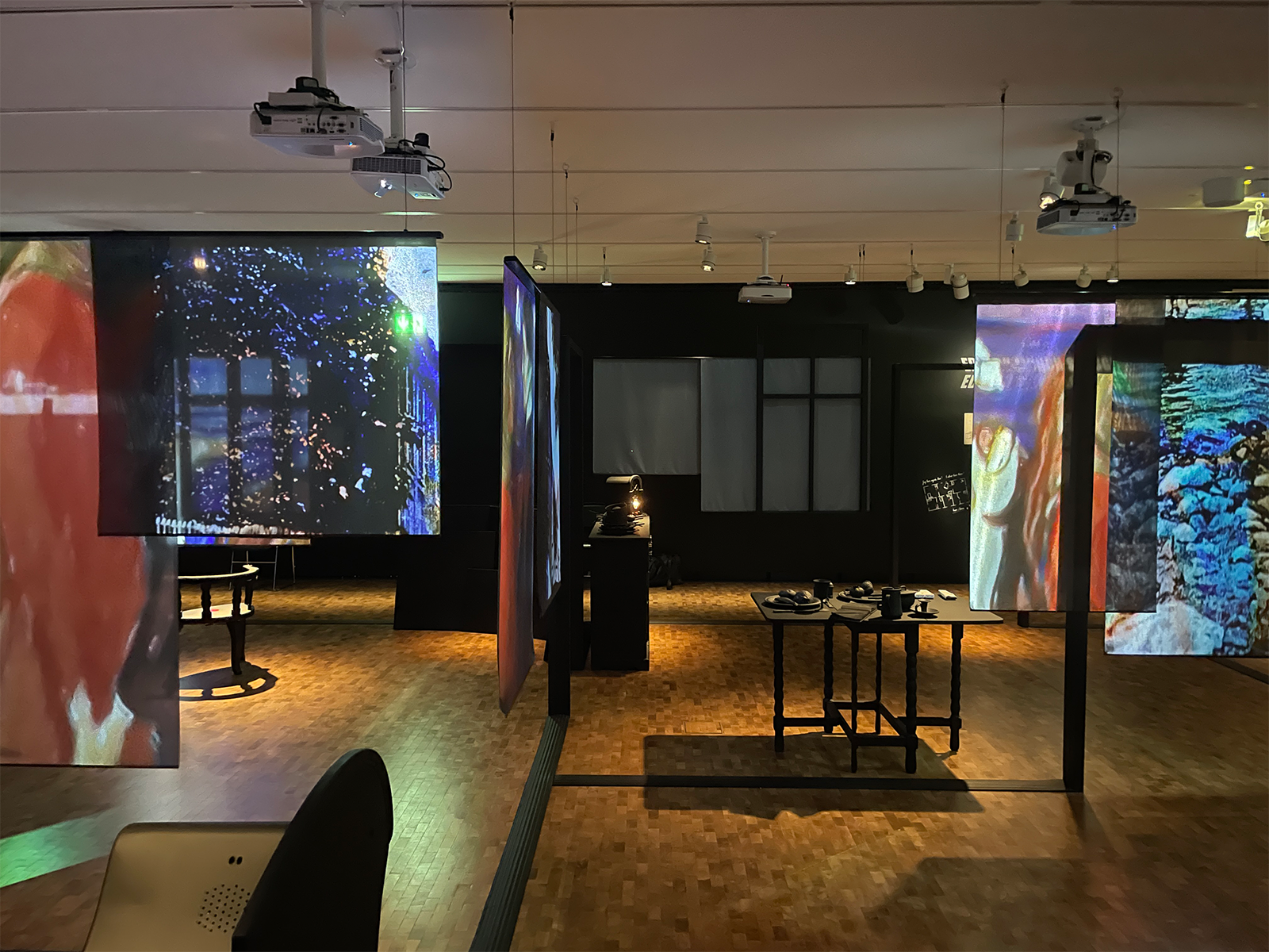 An example of visual storytelling in design at the Munch Museum, where an exhibition designed by the article’s author displays artworks projected onto canvases around the room.