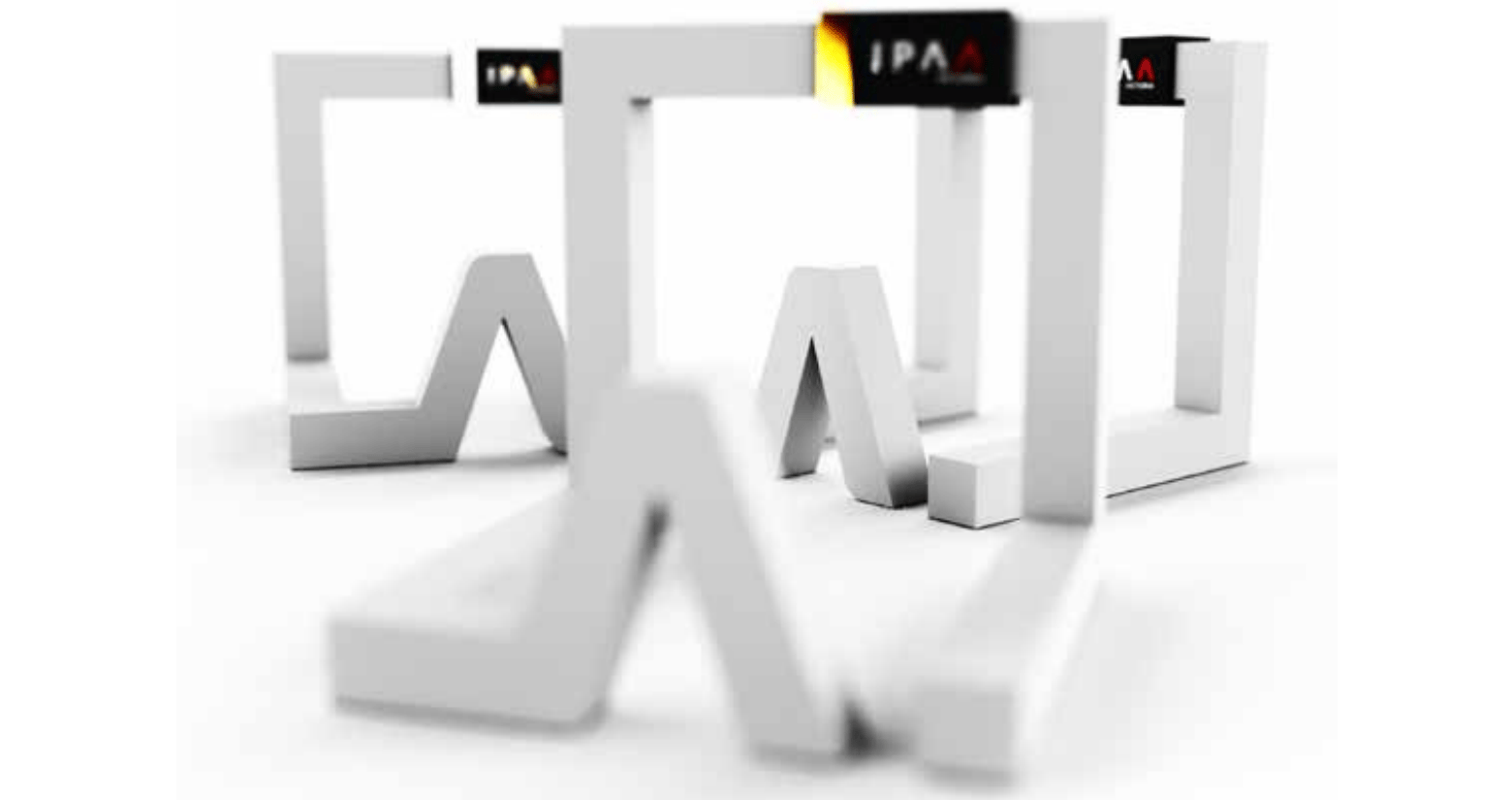 A photograph of three IPAA trophies. The trophies are an abstract cube shape rendered in white, with a distinctive “A” form projecting on the front plane. At the top is a black label with IPAA inscribed into it.