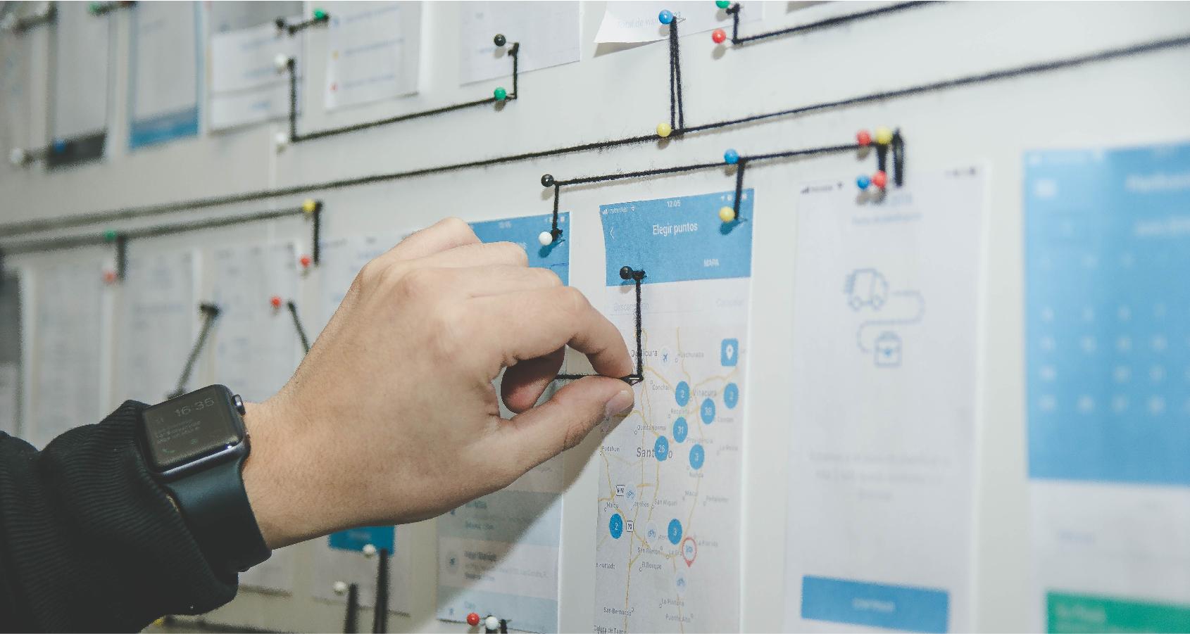 A designer uses pins and prints to determine the enterprise application UX design.