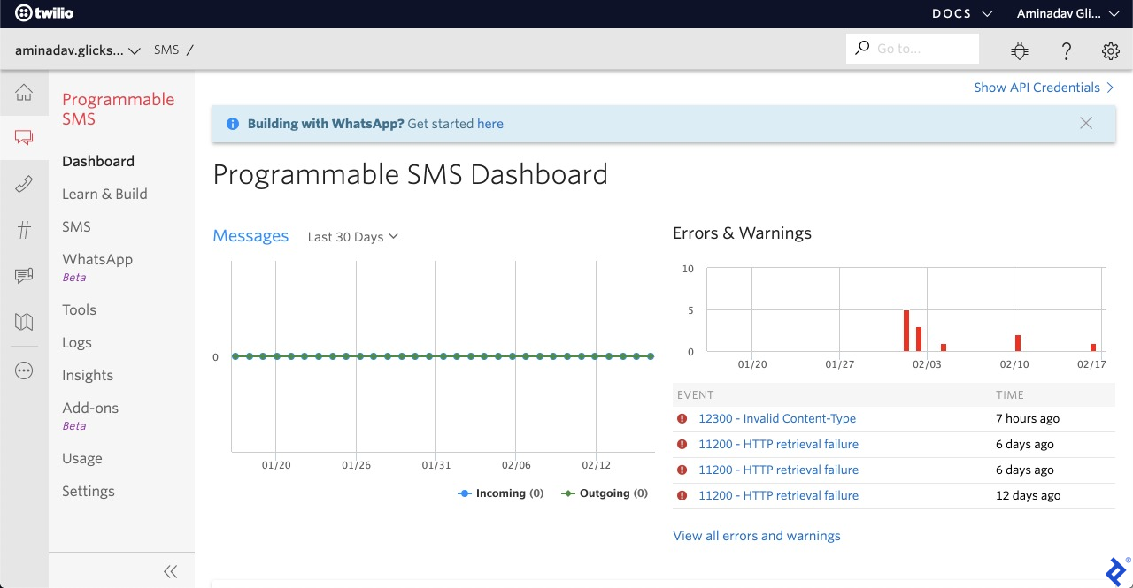 A screenshot of Twilio's "Programmable SMS Dashboard," showing a graph of recent messages, and another graph of recent errors and warnings. The fourth option in the navbar is "WhatsApp Beta."